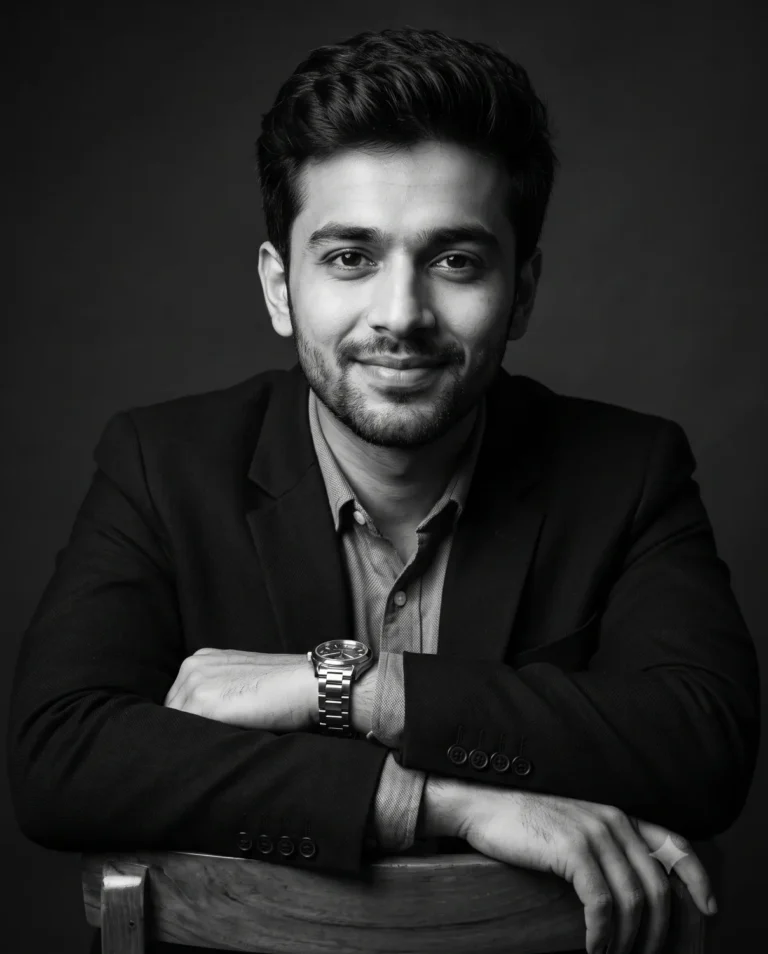 A smiling man in a suit created with this black and white prompt, featuring dramatic chiaroscuro studio lighting.