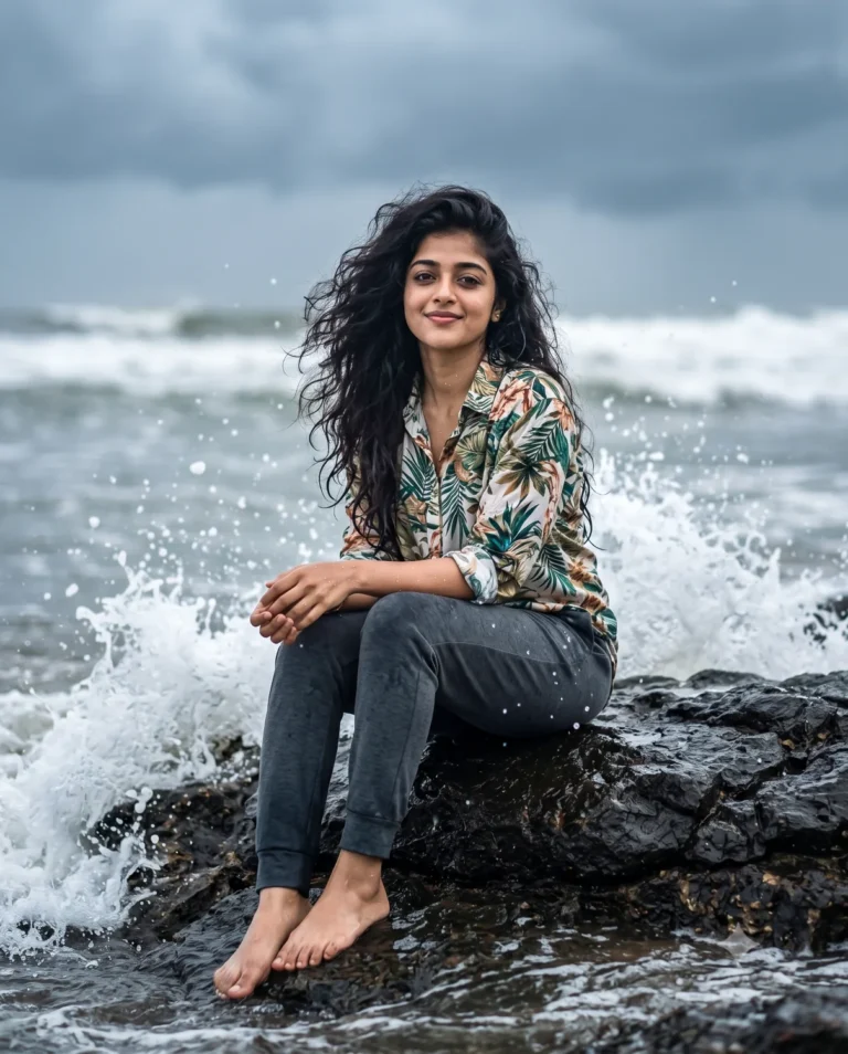 A young woman sitting on wet rocks with crashing waves generated from a realistic beach photo prompt.